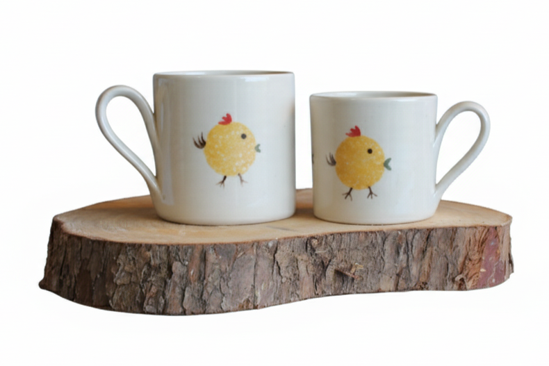 Stable Door Pottery two ceramic mugs with chicken designs on a wooden stand against a white background