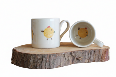 Stable Door Pottery two handmade ceramic mugs with hand-painted chickens on a wooden surface