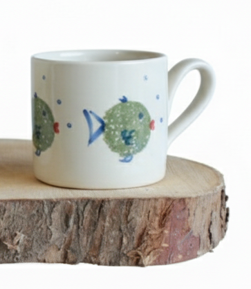 Stable Door Potter Small white mug with fish designs on a wooden surface